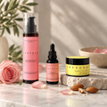 The Complete Barrier Shield Set natural skincare products—featuring Rose Micellar Water, Rose Dermal Restoration Oil, and Dermal Balsam—displayed on stone with dried rose petals.